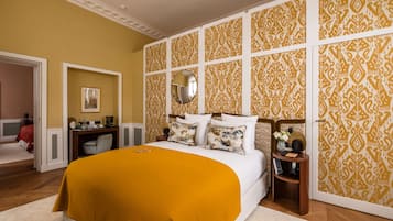 Une chambre à coucher avec un grand lit, un miroir au-dessus et un papier peint à motifs.