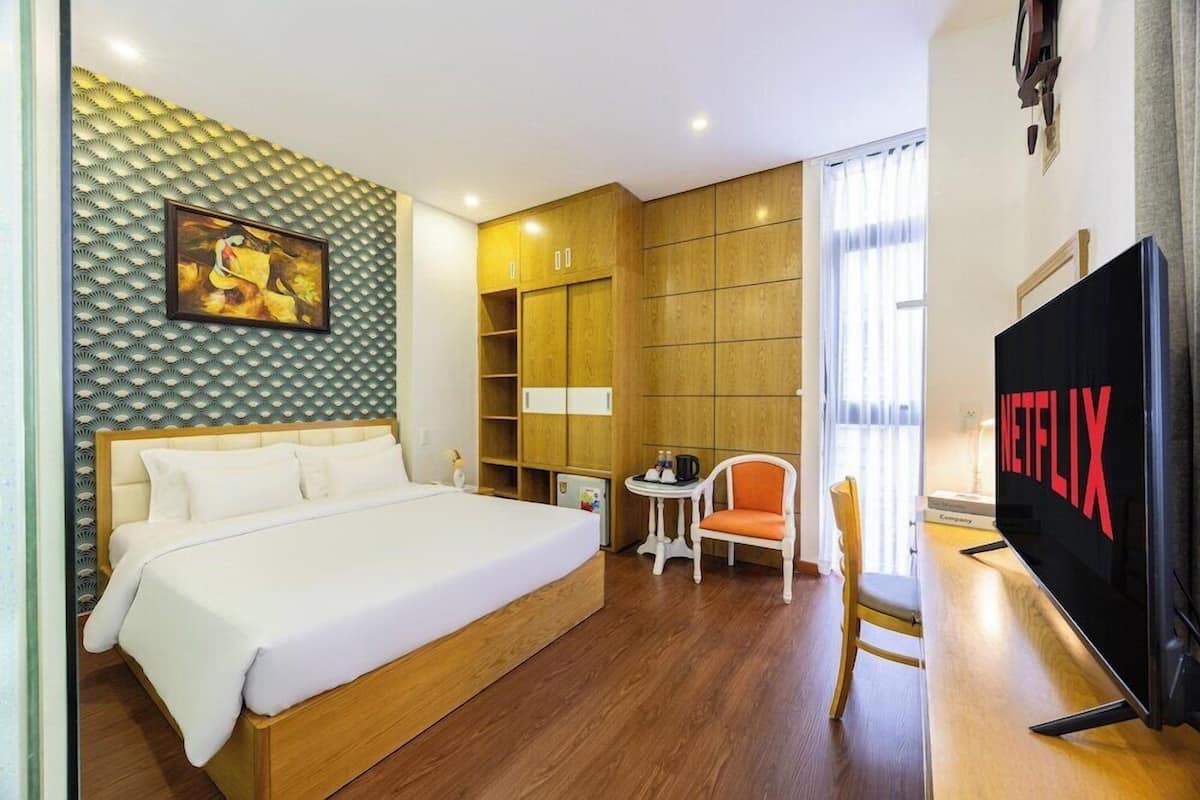 A hotel room with a bed, a television, a desk, and a chair.