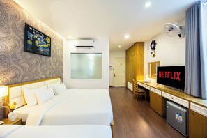 Une chambre d’hôtel avec un lit, un bureau sur lequel se trouve un téléviseur affichant « NETFLIX », un climatiseur fixé au mur et une horloge.