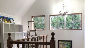 A staircase with wooden balusters, a chandelier, and a painting on the wall. - Horse Shoe Manor. 马蹄庄园 Bay of islands. Paihia (parakara)