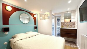 A modern bedroom with a large bed, a built-in vanity, and a large mirror.