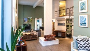 Amplia sala de estar con sofá, mesa de centro y una escalera que conduce a un piso superior.
