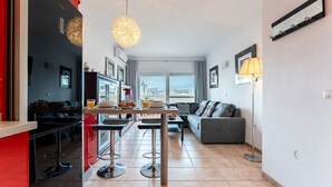 A modern apartment with a kitchen, dining area, and living room.