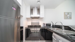 Una cucina moderna con elettrodomestici in acciaio inossidabile, forno integrato, microonde e lavastoviglie.