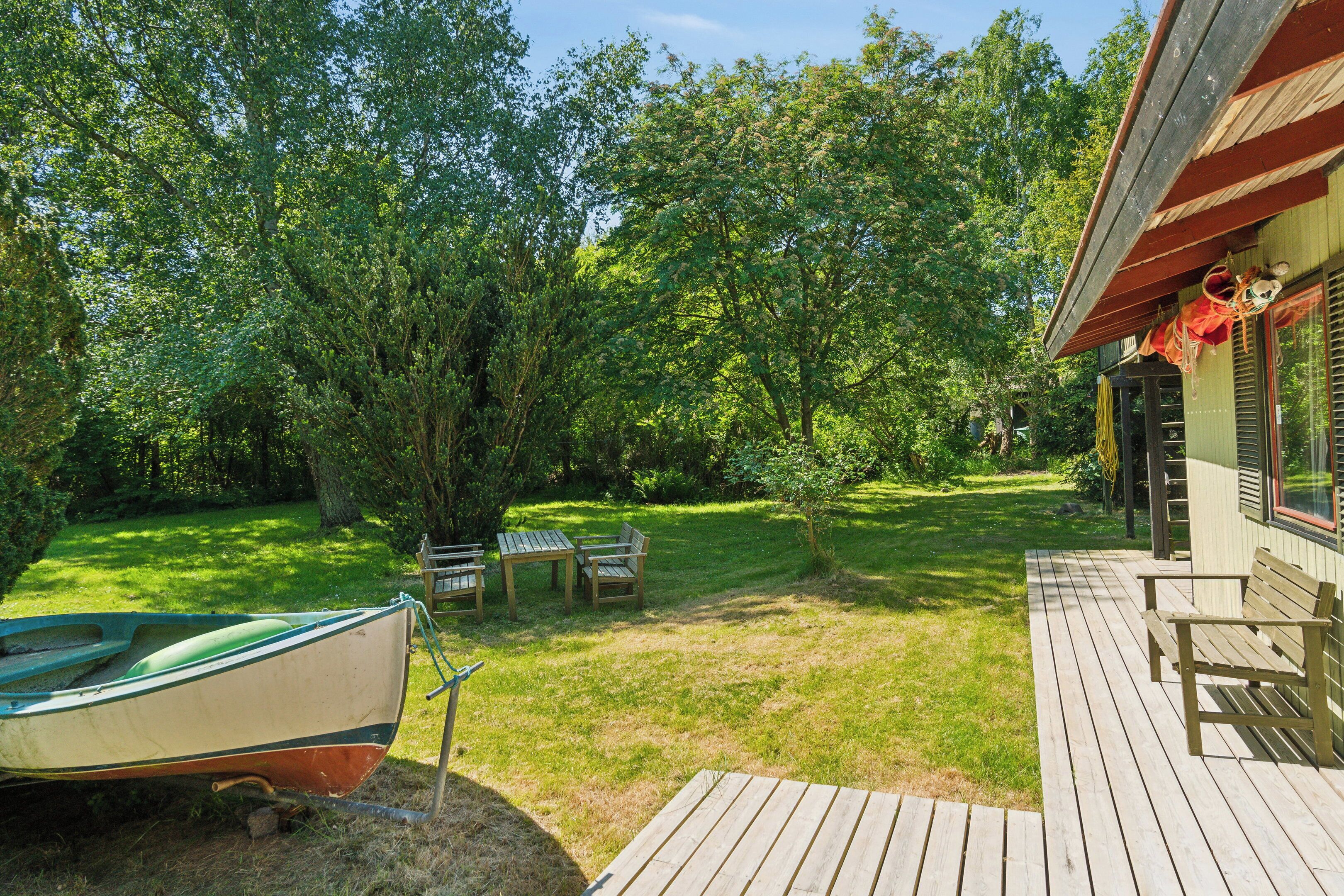 Une terrasse en bois, un bateau et un bâtiment doté d’un porche.