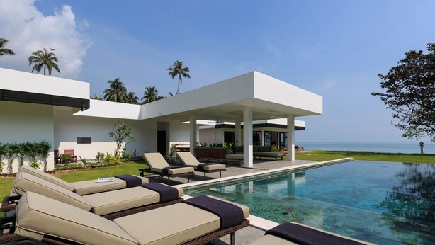 A modern resort with a pool, lounge chairs, and a view of the ocean. - Villa Thansamaay by Elite Havens (Koh Samui)