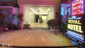 The exterior of the Royal Hotel with a prominent neon sign, a Christmas tree, and potted plants. - Hoang Gia I Hotel Yen Xa - by Bay Luxury (Hanoi)