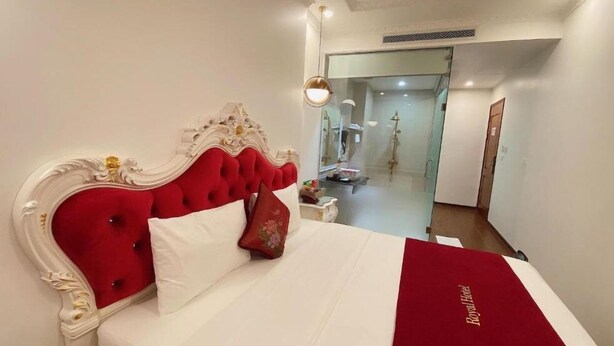 A hotel room with a red upholstered headboard, white bedding, and a red throw blanket. - Hoang Gia I Hotel Yen Xa - by Bay Luxury (Hanoi)