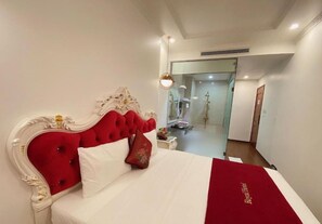 A hotel room with a red upholstered headboard, white bedding, and a red throw blanket. - Hoang Gia I Hotel Yen Xa - by Bay Luxury (Hanoi)