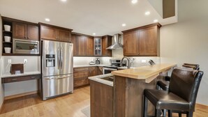 A modern kitchen with wooden cabinets, stainless steel appliances, and a central island.