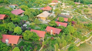 A cluster of houses with red roofs, surrounded by lush greenery and terraced fields. - Van Ho Ecolodge (Van Ho)