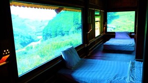 A train compartment with two beds, large windows, and a view of a green landscape. - Van Ho Ecolodge (Van Ho)