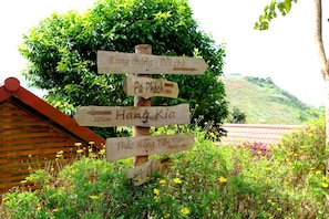 A wooden signpost with directional arrows pointing to various destinations. - Van Ho Ecolodge (Van Ho)