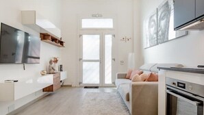A modern kitchen with a built-in oven, a large window, and a flat-screen TV. - New and cozy Apartment in Center (Milano)