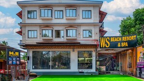 Un edificio de dos pisos con un cartel que dice 'WS Beach Resort & Spa' en el lado derecho.