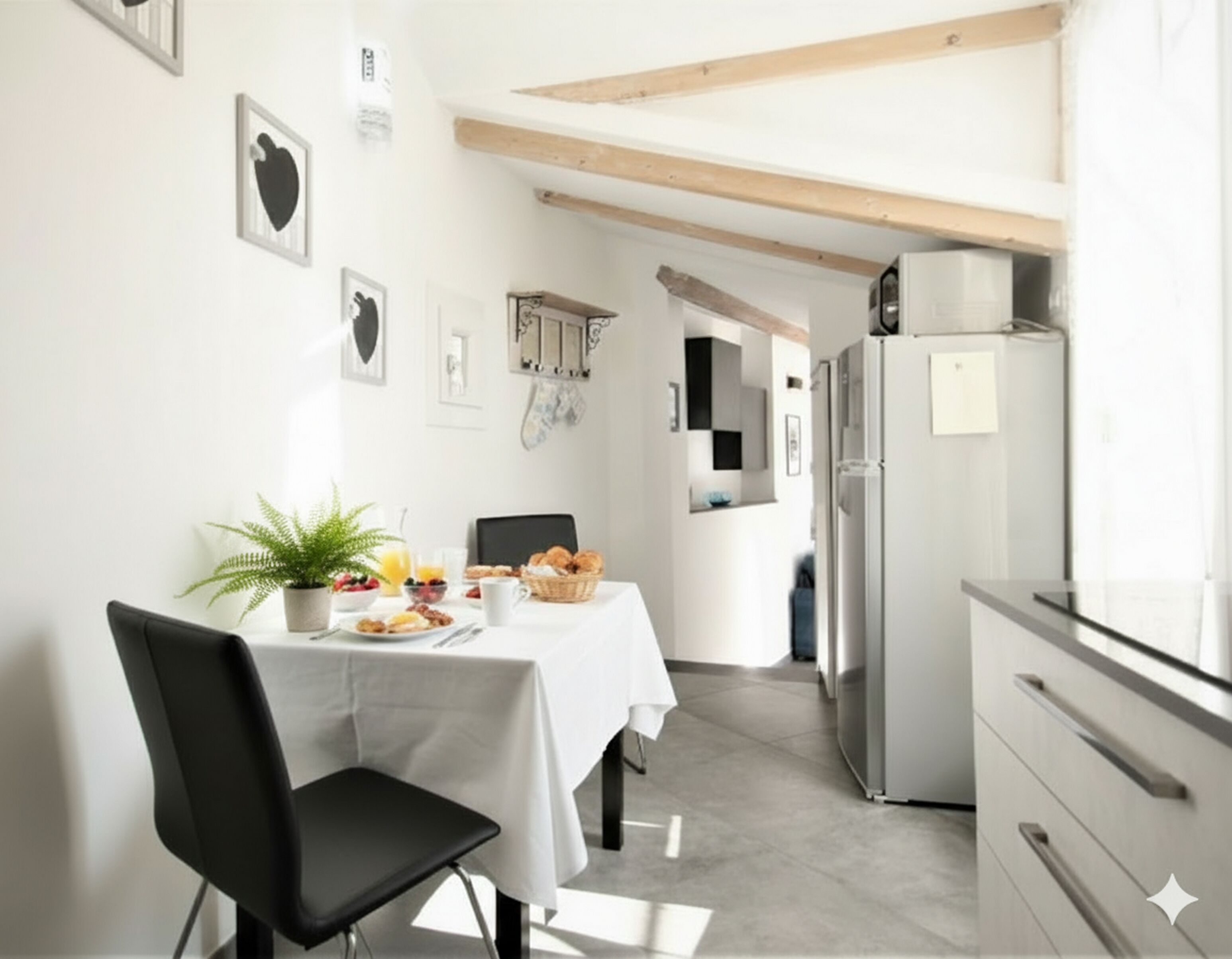 A modern kitchen with a dining table set for breakfast, a refrigerator, and a potted plant.