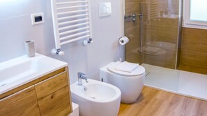 A modern bathroom with a bathtub, a sink, a toilet, and a glass shower enclosure. - BARONIO APARTMENT ONLY 10 MINUTES BY METRO TO THE CENTRE (Roma)