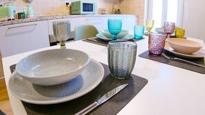 A dining table with patterned plates, a knife, and colorful glassware. - BARONIO APARTMENT ONLY 10 MINUTES BY METRO TO THE CENTRE (Roma)