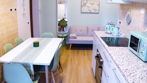 A compact kitchen with a dining table, chairs, a sofa, and vintage appliances. - BARONIO APARTMENT ONLY 10 MINUTES BY METRO TO THE CENTRE (Roma)