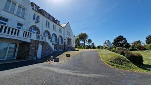 A large, white building with multiple windows and a stone facade. - Flat in Primel with Sea View & Beaches Nearby (Plougasnou)