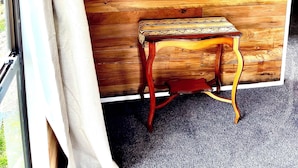 Une pièce aux murs en bois, avec un miroir et une petite table.