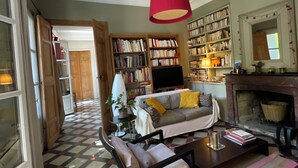 Una sala de estar con suelo a cuadros, un sofá, una mesa de centro, una chimenea y una estantería.