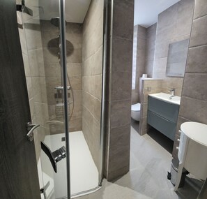 Regadera, secadora de cabello, toallas, papel de baño 
