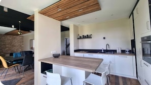 A modern kitchen with white cabinets, a wooden countertop, and a built-in oven. - Beautiful Villa, calm, 5 minutes walk to the beach. Walking distance to town. (Saint-Raphaël)
