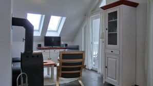 A room with a loft bed, a television, a cabinet, and a window. - Strandnahe Lage - MIT Balkon - Kaminofen- Wlan (Graal-Müritz)