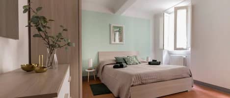 A bedroom with a bed, bedside table, and a window.