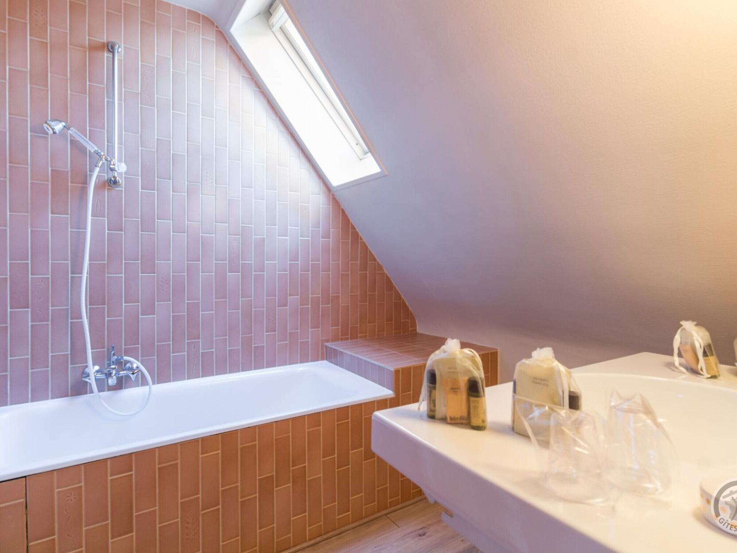 Un baño con bañera, ducha y tocador con artículos de aseo.