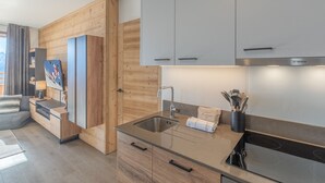 A modern kitchen with wooden cabinetry, a built-in oven, and a stainless steel sink. - Bright apartment with terrace and parking in Alpe d'Huez (Huez)