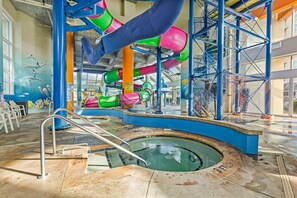 Ein Wasserpark im Innenbereich mit Pool, Rutschen und einem Delfin-Mural.