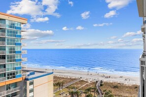 Un edificio de gran altura con vistas a la playa y al océano.