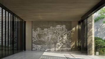 Un interior moderno con un gran mural que representa un paisaje tradicional, un techo inclinado y un suelo con un diseño geométrico.