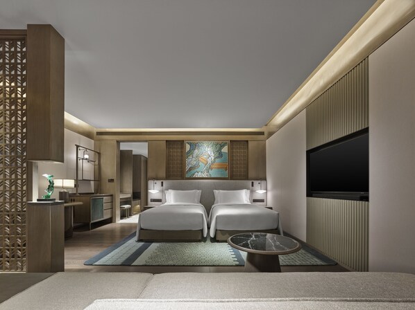 A modern hotel room with two beds, a TV, a desk with a lamp, and a decorative wall piece. - Banyan Tree Suzhou Shishan (Suzhou)