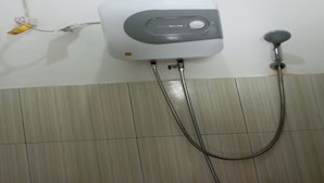 A wall-mounted shower unit with a control panel and a handheld showerhead. - OYO Life 92543 Ratu Sakti Residence Syariah (Semarang)