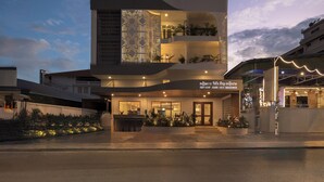 A modern hotel with a prominent entrance, multiple balconies, and a lit facade. - SIEM REAP RIVER VIEW RESIDENCE (Siem Reap)