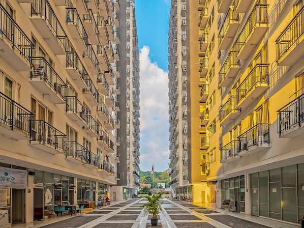A multi-story hotel with balconies, a central courtyard, and a view of the surrounding area. - OYO Life 92649 Jarrdin Apartment By Glory (Bandung)