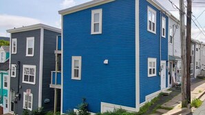 Een woonhuis met twee verdiepingen, een blauwe gevel en witte accenten.