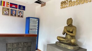 A reception area with a Buddha statue, framed pictures, and a welcome mat. - UMA Residence (Siem Reap)