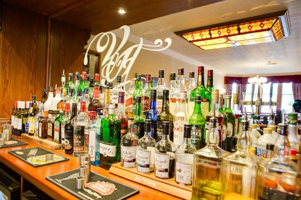 A bar area with a variety of liquor bottles and a sign that reads "BAYTOWN".