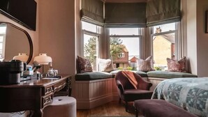 A bedroom with a bay window, a desk with a lamp, a chair, and a bed. - Hotel Victoria (Whitby)