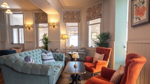 A living room with a tufted sofa, a coffee table, and two armchairs. - Hotel Victoria (Whitby)