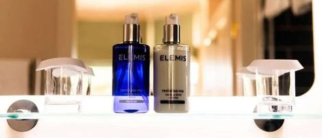 Two bottles of Elemis Revitalize Me Body Lotion on a bathroom counter.