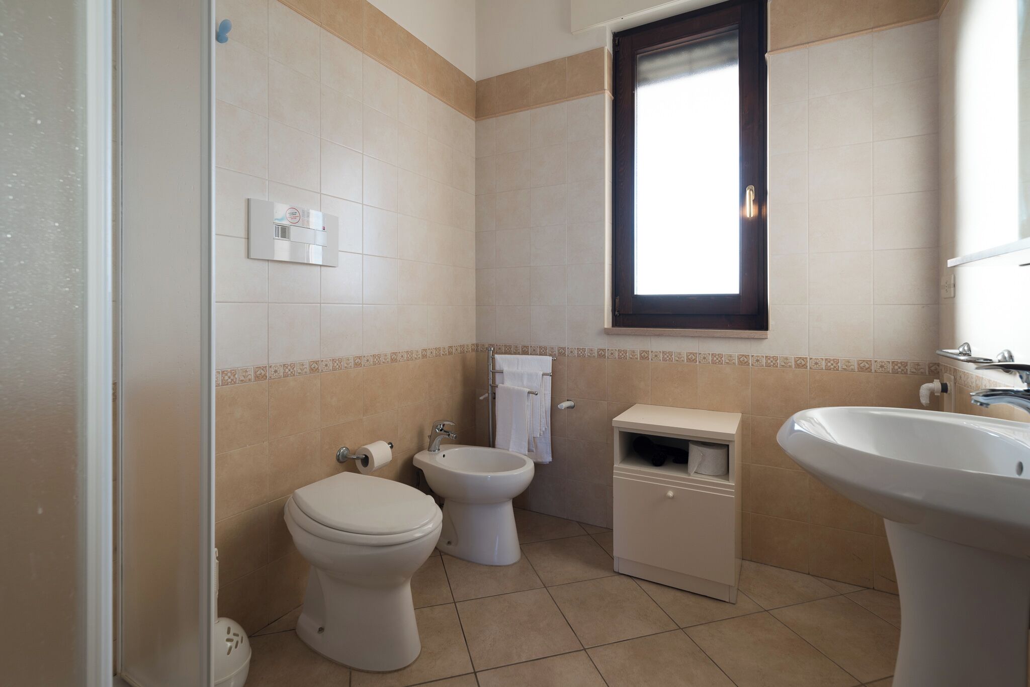 Ein Badezimmer mit Toilette, Bidet und Waschbecken.