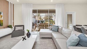 Una sala de estar moderna con un sofá, una mesa de centro y un comedor con una mesa y sillas.