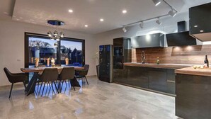 Una cocina moderna con comedor, ventanas amplias y vistas al exterior.