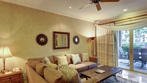 Un salon avec un canapé, une table basse et un ventilateur de plafond.