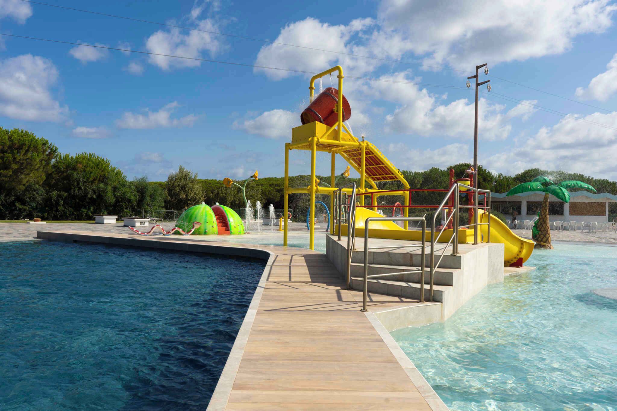 Ein Schwimmbecken mit Wasserrutsche und kleinem Wasserfall.